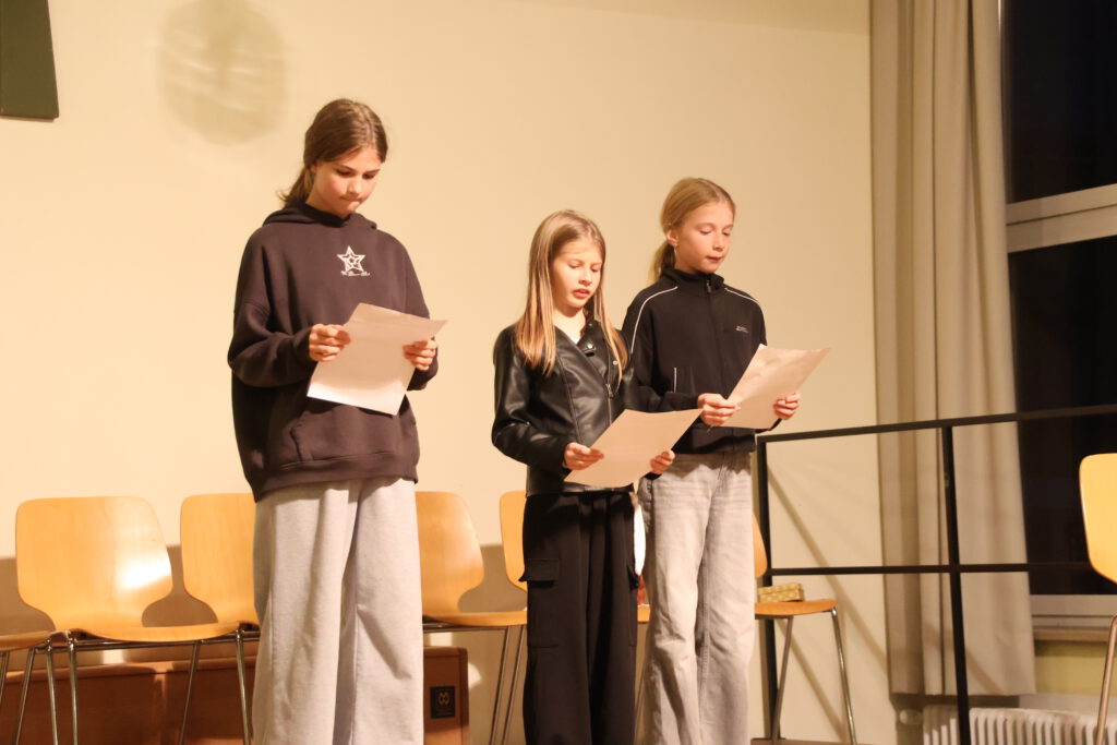 Drei junge Mädchen von der jungen Bühne zeigen auf, wie Theater in 2035 aussehen könnte, wenn die KI übernimmt